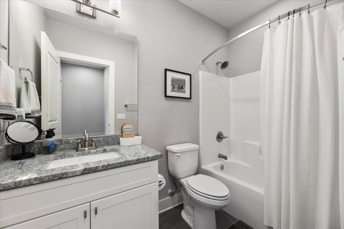 995 Airport Road, Unit 26 Destin, FL 32541 - Photo 30 of 39 a bathroom with a granite countertop sink toilet and shower