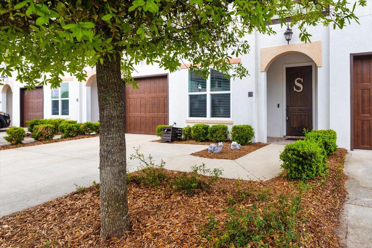 995 Airport Road, Unit 26 Destin, FL 32541 - Photo 4 of 39 a front view of a house with a yard and potted plants