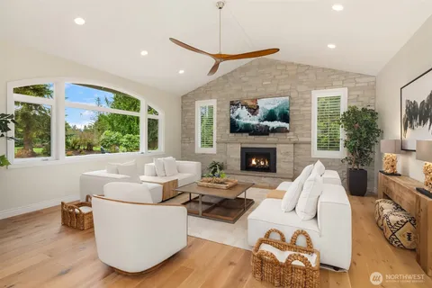 a living room with furniture fireplace and a large window