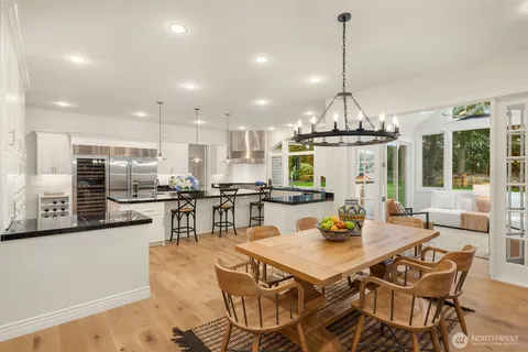 a view of a dining room and livingroom with furniture wooden floor a chandelier