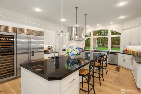 a kitchen with stainless steel appliances granite countertop a sink a stove and a refrigerator