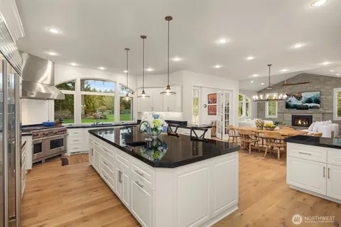 a kitchen with stainless steel appliances kitchen island granite countertop a stove a sink and a refrigerator