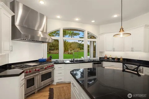 a kitchen with stainless steel appliances granite countertop a stove a sink and a microwave