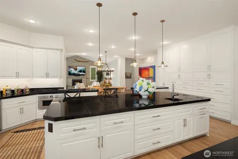 a kitchen with stainless steel appliances granite countertop white cabinets a stove a sink and dishwasher