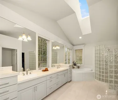 a large bathroom with a double vanity sink a large mirror and a bathtub