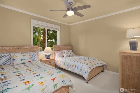 a bedroom with two beds and large windows