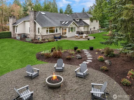 a view of a house with backyard sitting area and a garden