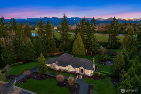a view of a lake in front of a house with a yard