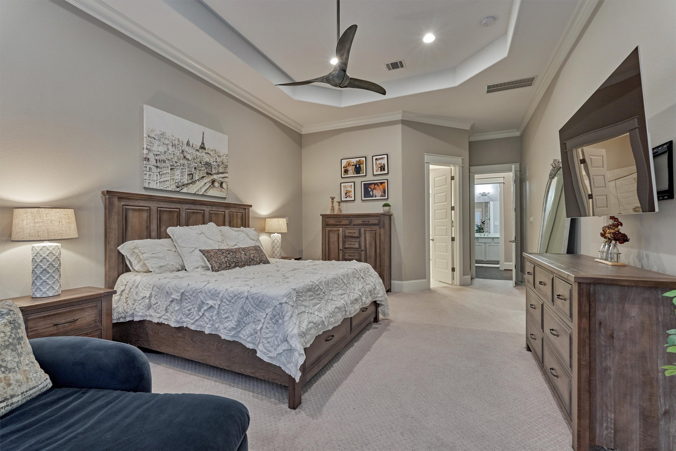 2227 Blue Duck Lane Conroe, TX 77384 - Photo 24 of 50 a spacious bedroom with a bed a couch and a flat tv screen on dresser