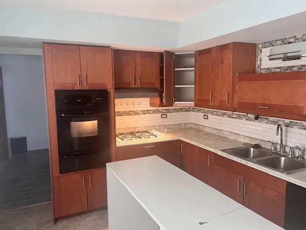 a kitchen with stainless steel appliances granite countertop a sink and a refrigerator