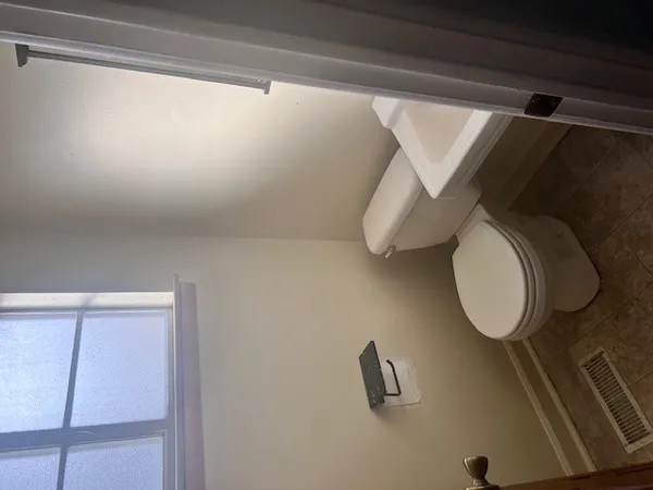 a bathroom with a toilet and a shower