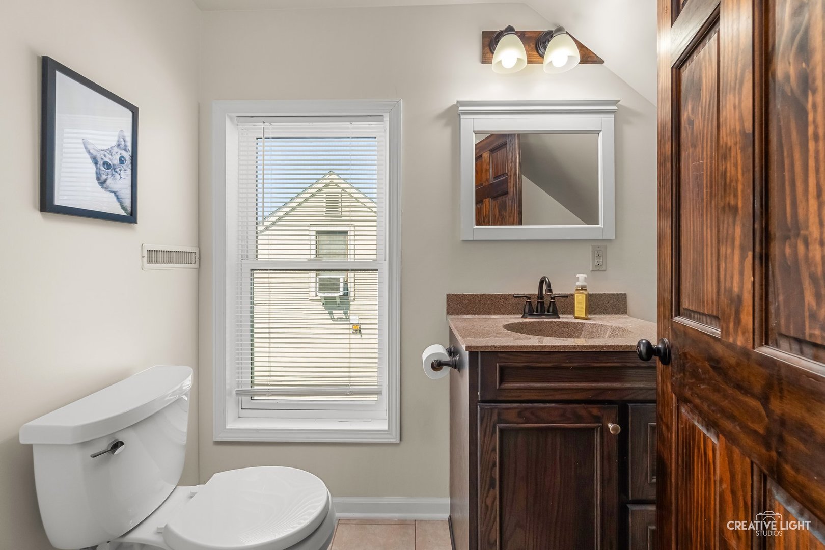 1606 Clark Street DeKalb, IL 60115 - Photo 14 of 20 a bathroom with a toilet a sink and mirror
