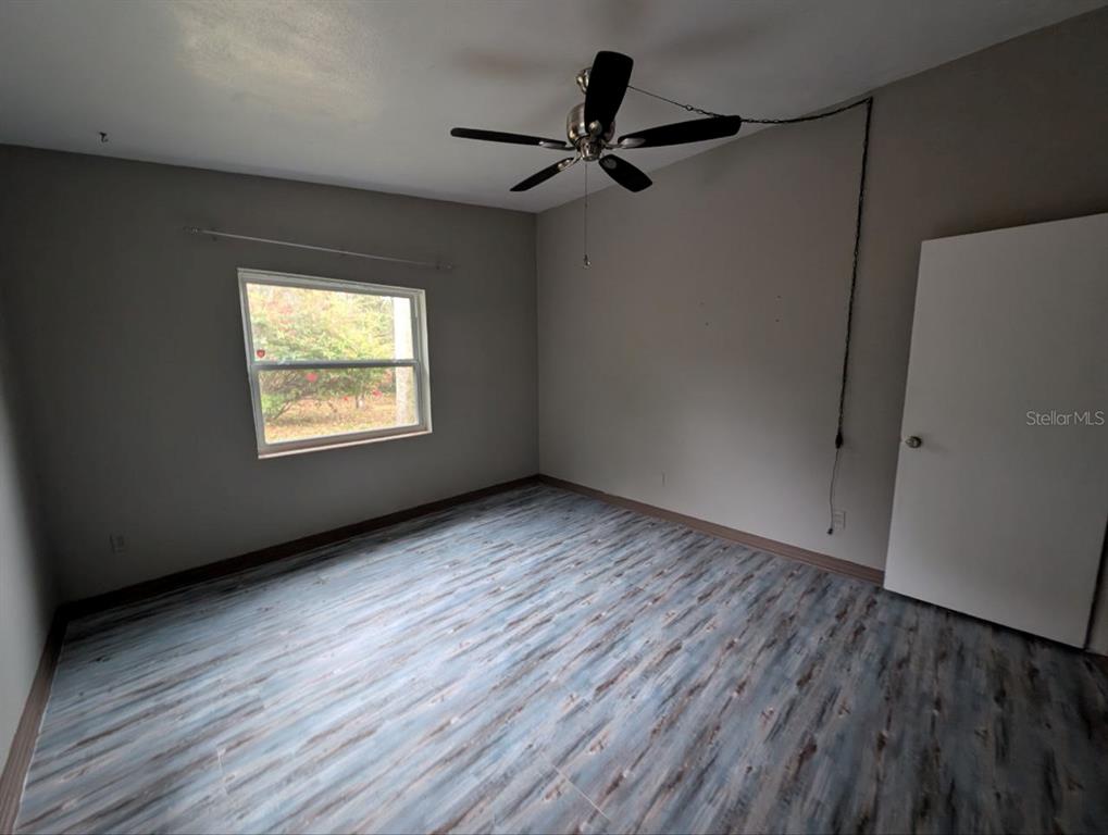 2304 Vine Street Leesburg, FL 34748 - Photo 12 of 25 a view of empty room with wooden floor and fan