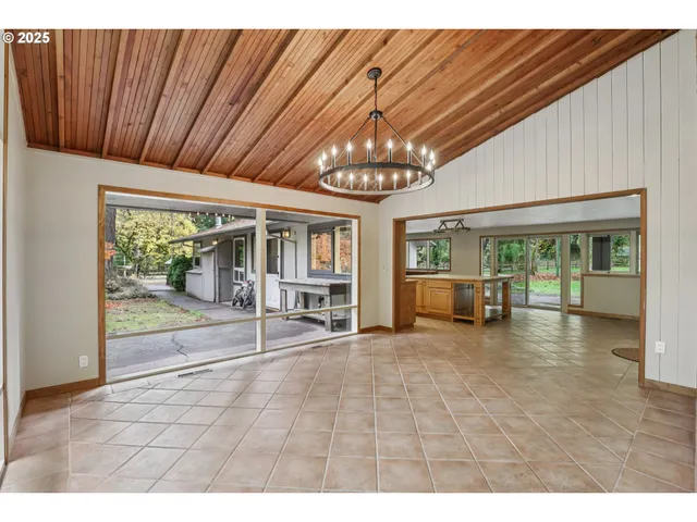 a view of an empty room with wooden floor and windows