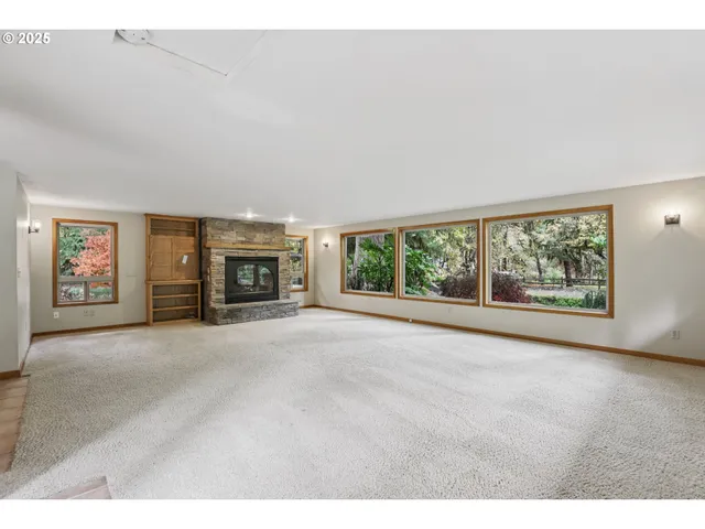 a view of an empty room with a fireplace and a window