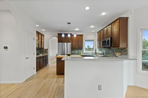 a kitchen with stainless steel appliances granite countertop a refrigerator a stove top oven a sink and dishwasher
