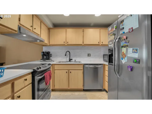 a kitchen with stainless steel appliances a stove a sink and cabinets