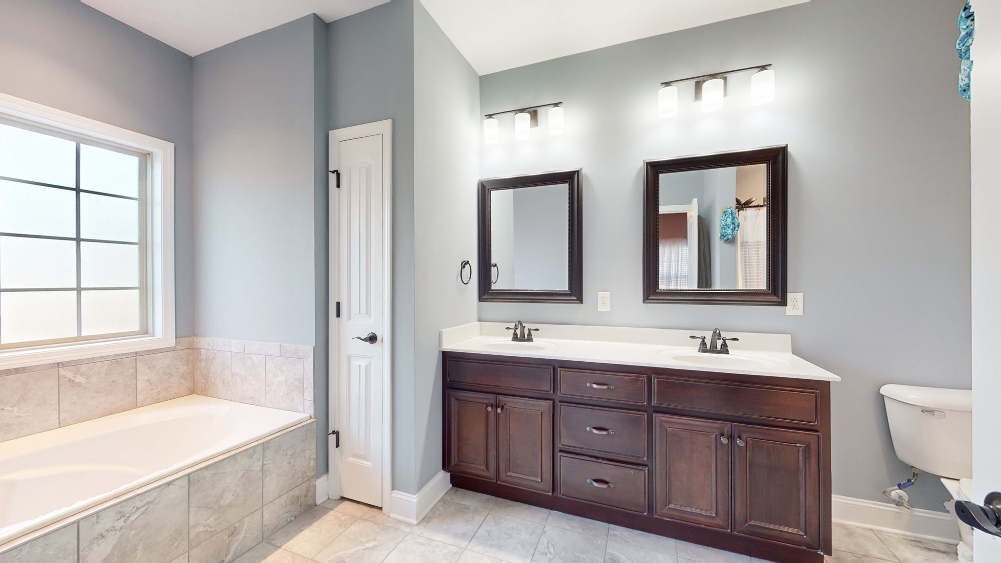 306 Patsy Place Smyrna, TN 37167 - Photo 18 of 34 a bathroom with a double vanity sink a large mirror a bathtub and