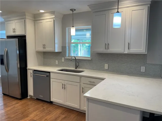 a kitchen with stainless steel appliances white cabinets and a sink