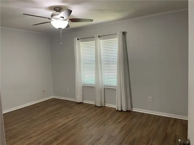 an empty room with wooden floor and window