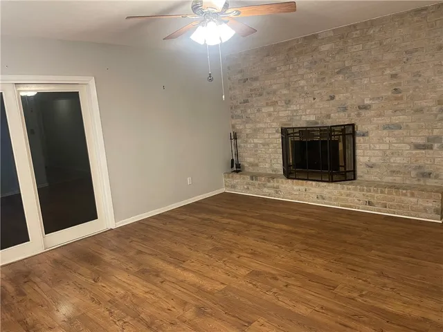 a view of empty room with wooden floor and fireplace