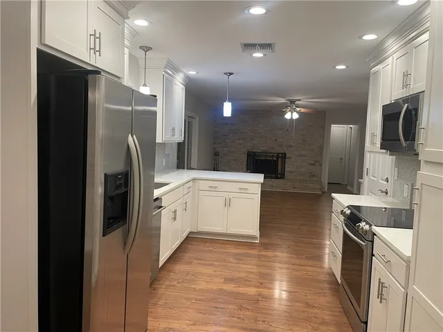 a kitchen with white cabinets and stainless steel appliances