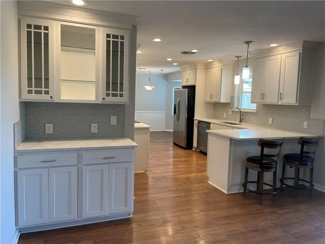 a kitchen with kitchen island granite countertop a sink and a refrigerator