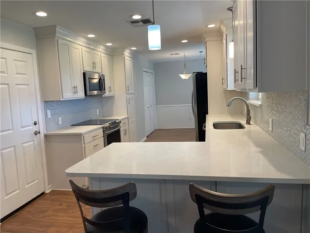 a kitchen with a table chairs sink and cabinets