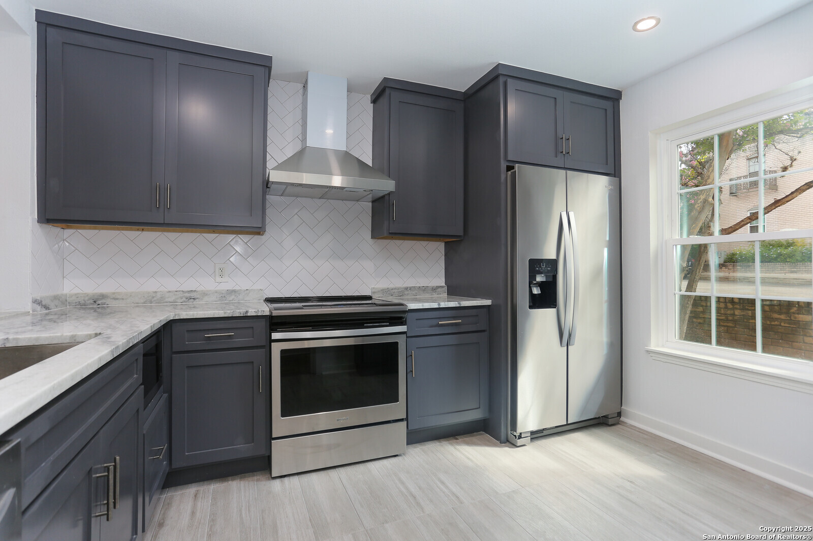 112 Ruelle Lane, Unit 112 San Antonio, TX 78209 - Photo 3 of 16 a kitchen with stainless steel appliances granite countertop a stove a refrigerator and a sink