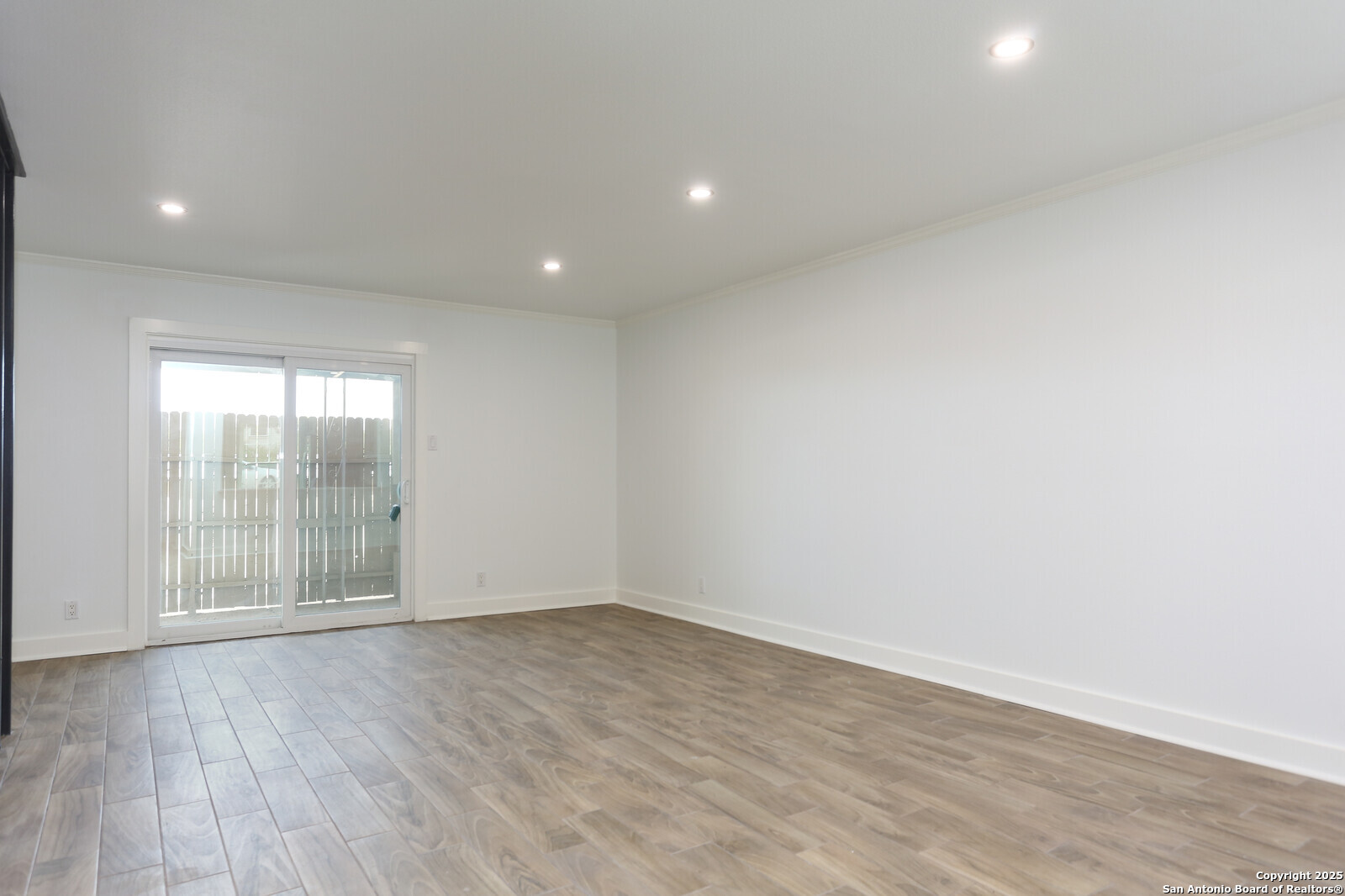 112 Ruelle Lane, Unit 112 San Antonio, TX 78209 - Photo 5 of 16 an empty room with wooden floor and windows