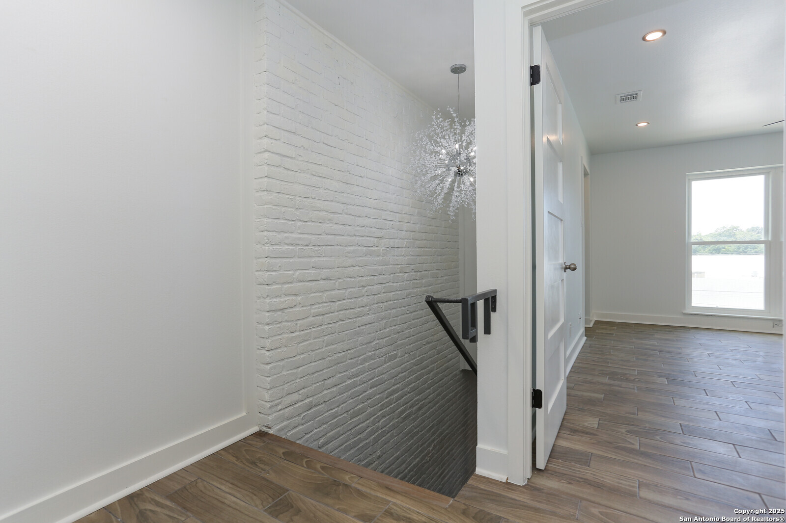 112 Ruelle Lane, Unit 112 San Antonio, TX 78209 - Photo 9 of 16 a view of a hallway with wooden floor and staircase