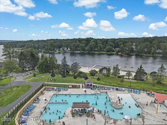 an aerial view of a house with a yard and lake view