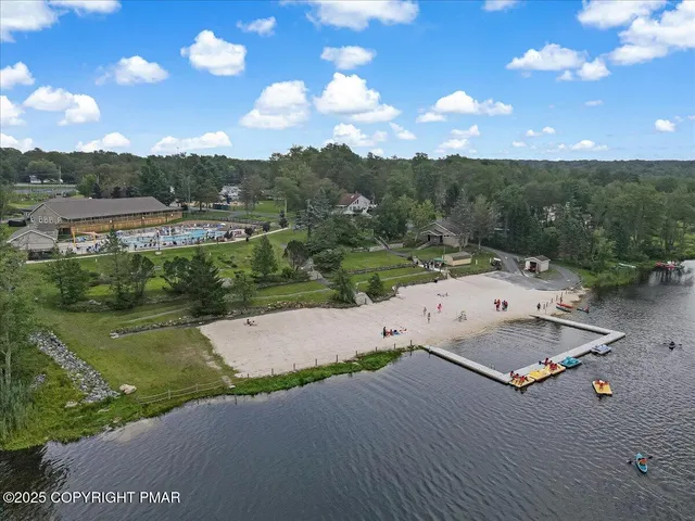 an aerial view of a house with a yard and lake view