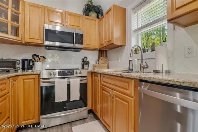 a kitchen with stainless steel appliances granite countertop a stove a sink and a microwave