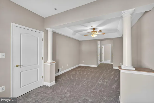 an empty room with closet and a chandelier fan