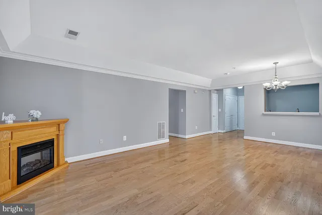 a view of an empty room with a fireplace and a window