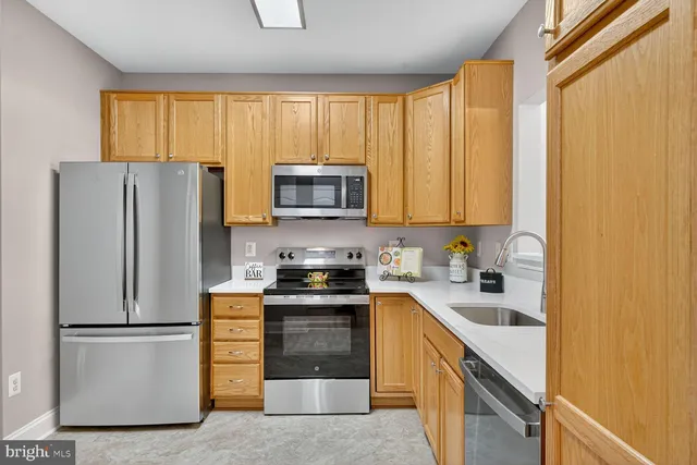 a kitchen with stainless steel appliances granite countertop a refrigerator stove a sink dishwasher and microwave with wooden floor