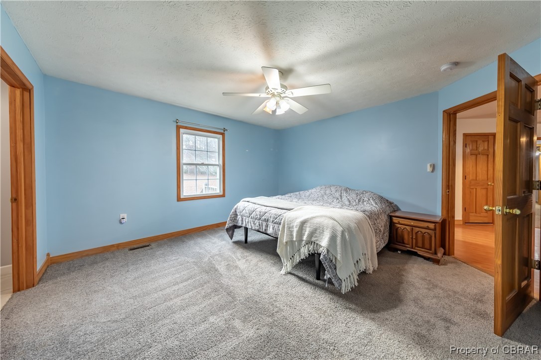 9534 Gee Farm Road Gloucester, VA 23061 - Photo 31 of 48 Carpeted bedroom with ceiling fan and a textured ceiling