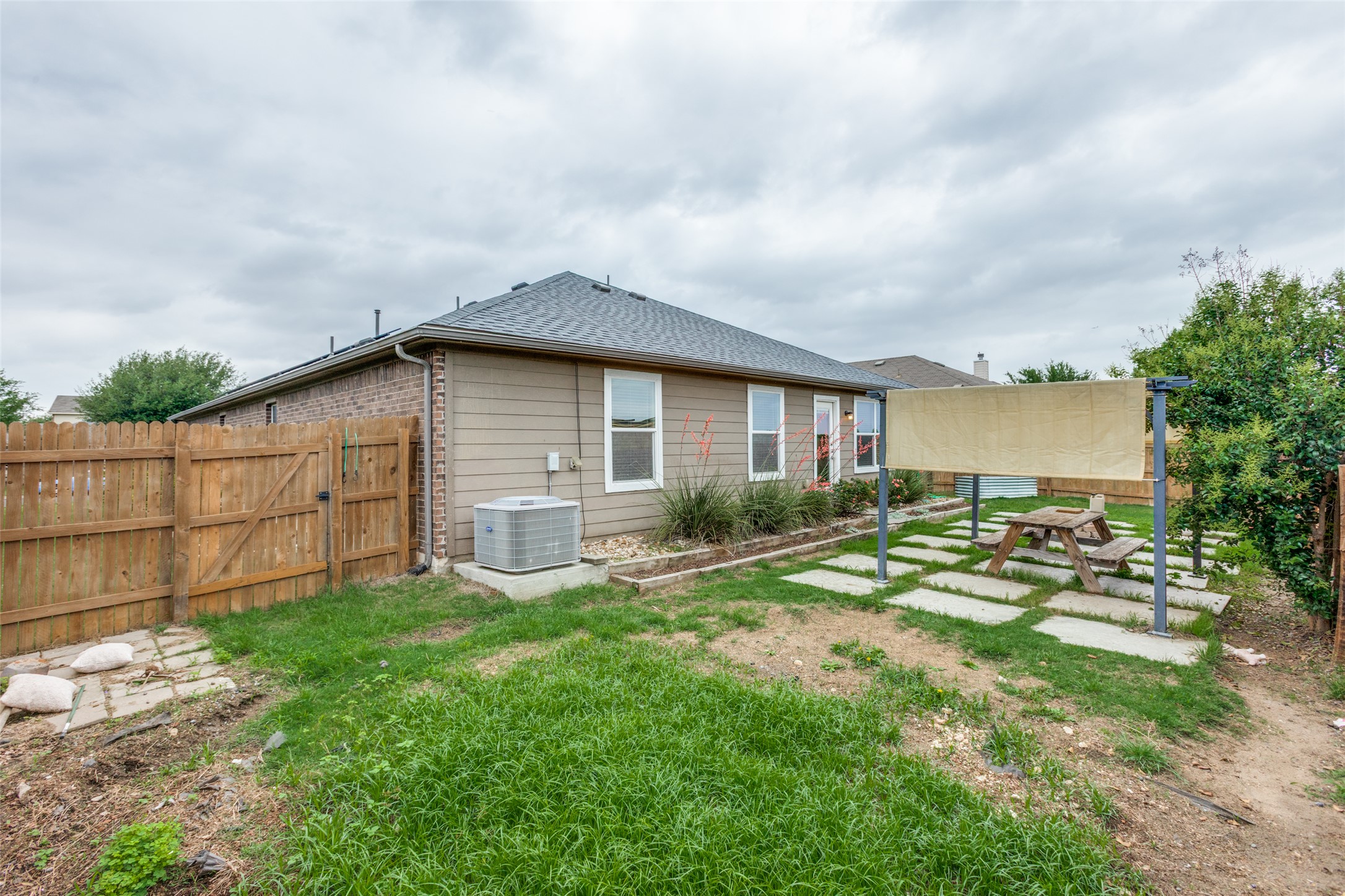 2909 Centrum Drive Austin, TX 78754 - Photo 29 of 30 The property features an exterior with siding and brick accents, a shingle roof, and a fenced yard