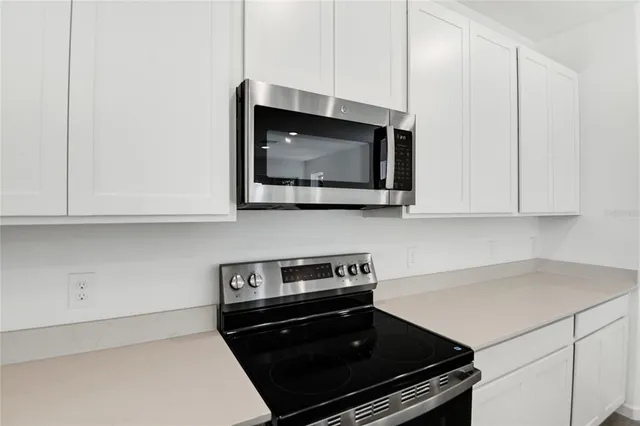 a kitchen with stainless steel appliances a stove and a microwave