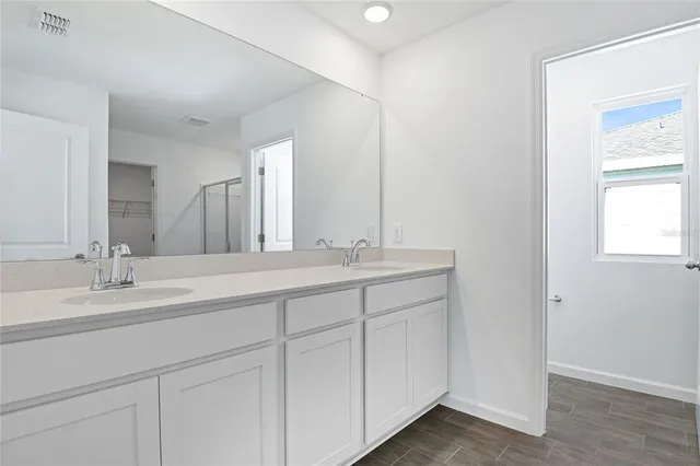 a bathroom with a double vanity sink and a mirror