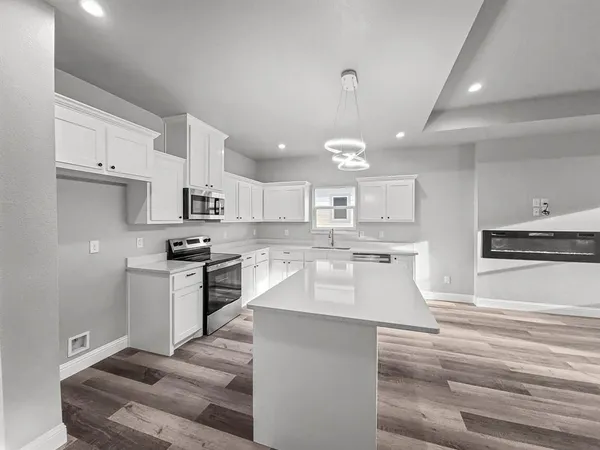 a large kitchen with kitchen island a sink stainless steel appliances and cabinets