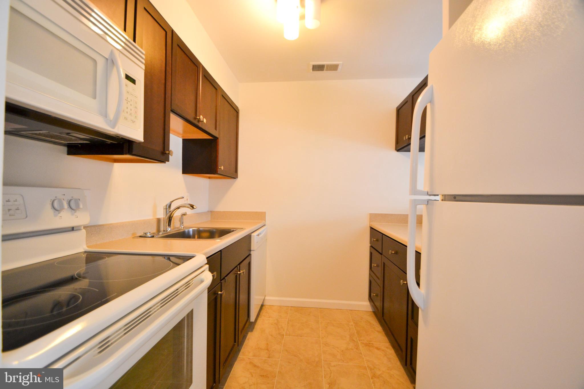 421 South Sharp Street, Unit R 11 Baltimore, MD 21201 - Photo 11 of 26 a kitchen with stainless steel appliances granite countertop a sink and a refrigerator
