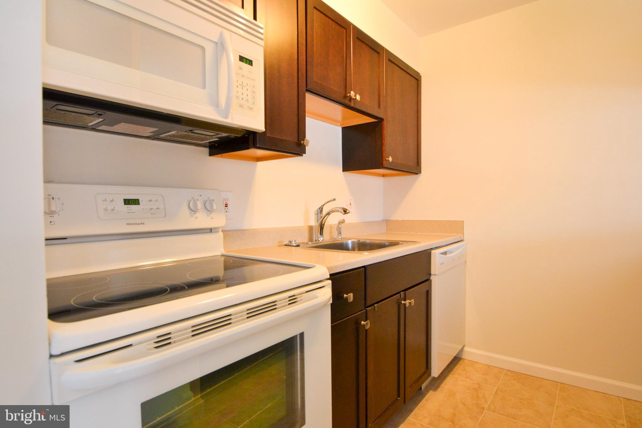 421 South Sharp Street, Unit R 11 Baltimore, MD 21201 - Photo 13 of 26 a kitchen with a sink cabinets and a wooden floor