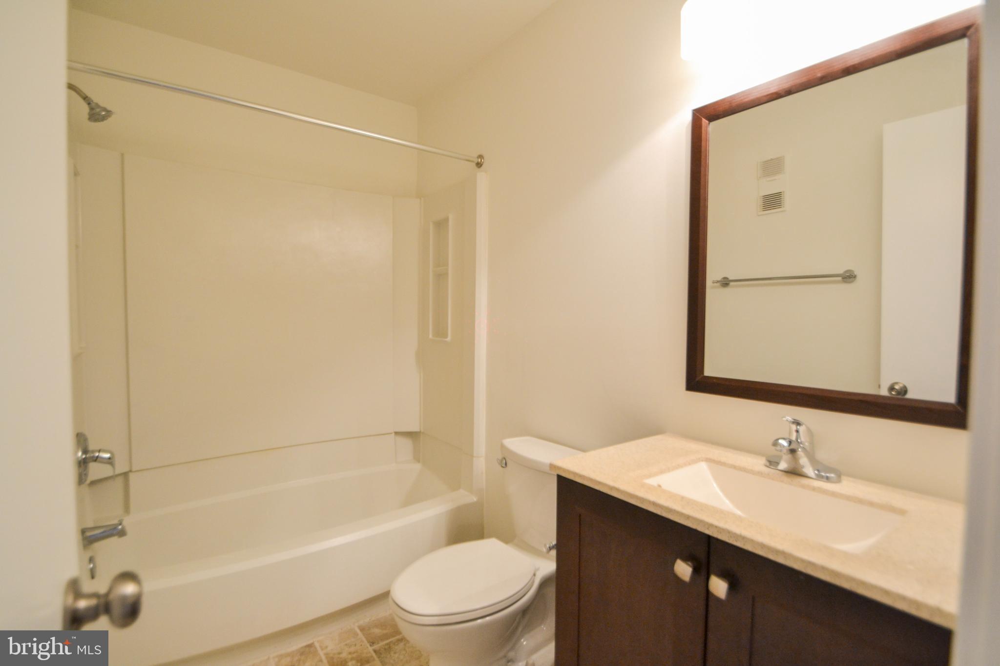 421 South Sharp Street, Unit R 11 Baltimore, MD 21201 - Photo 8 of 26 a bathroom with a granite countertop sink toilet and shower
