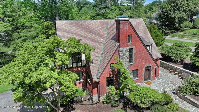 an aerial view of house with yard and trees in the background