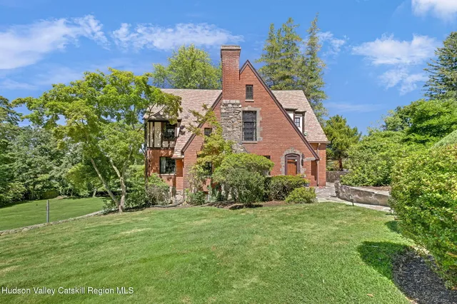 a view of a house with a big yard plants and large trees