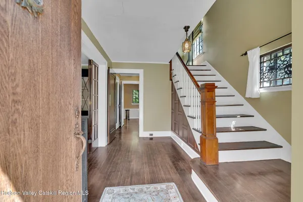 a view of a hallway with wooden floor and staircase