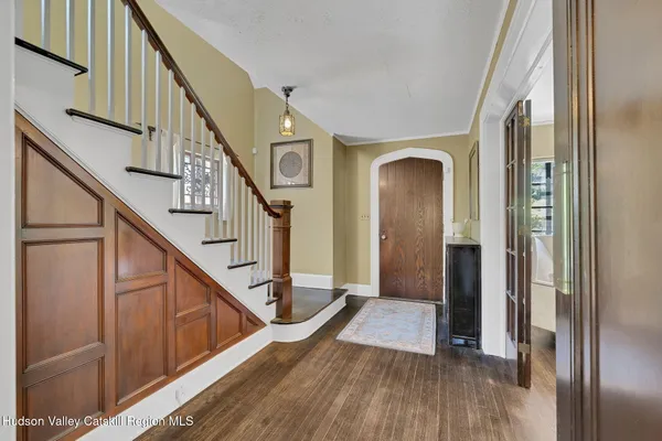 a view of a hallway with wooden floor and staircase