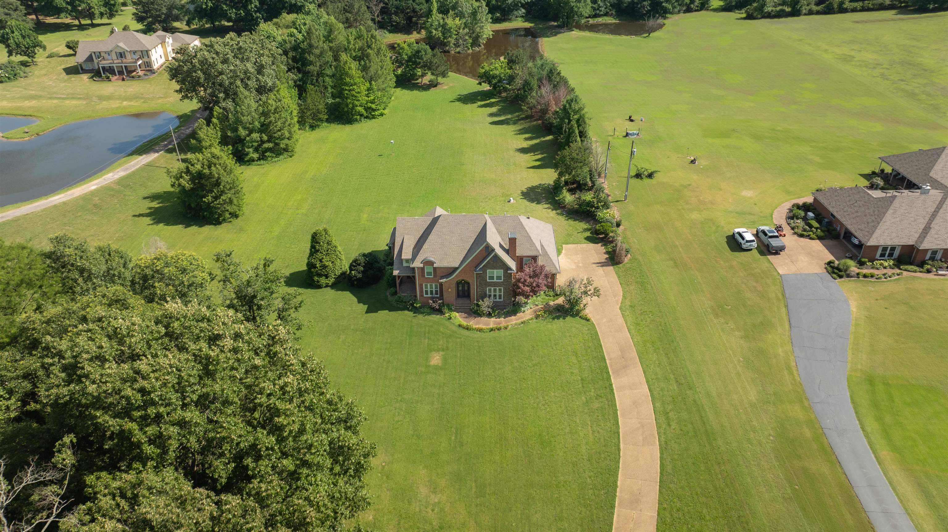680 Highway 193 Collierville, TN 38017 - Photo 37 of 38 Brick residence with a prominent gabled roof, situated on an expansive green lawn